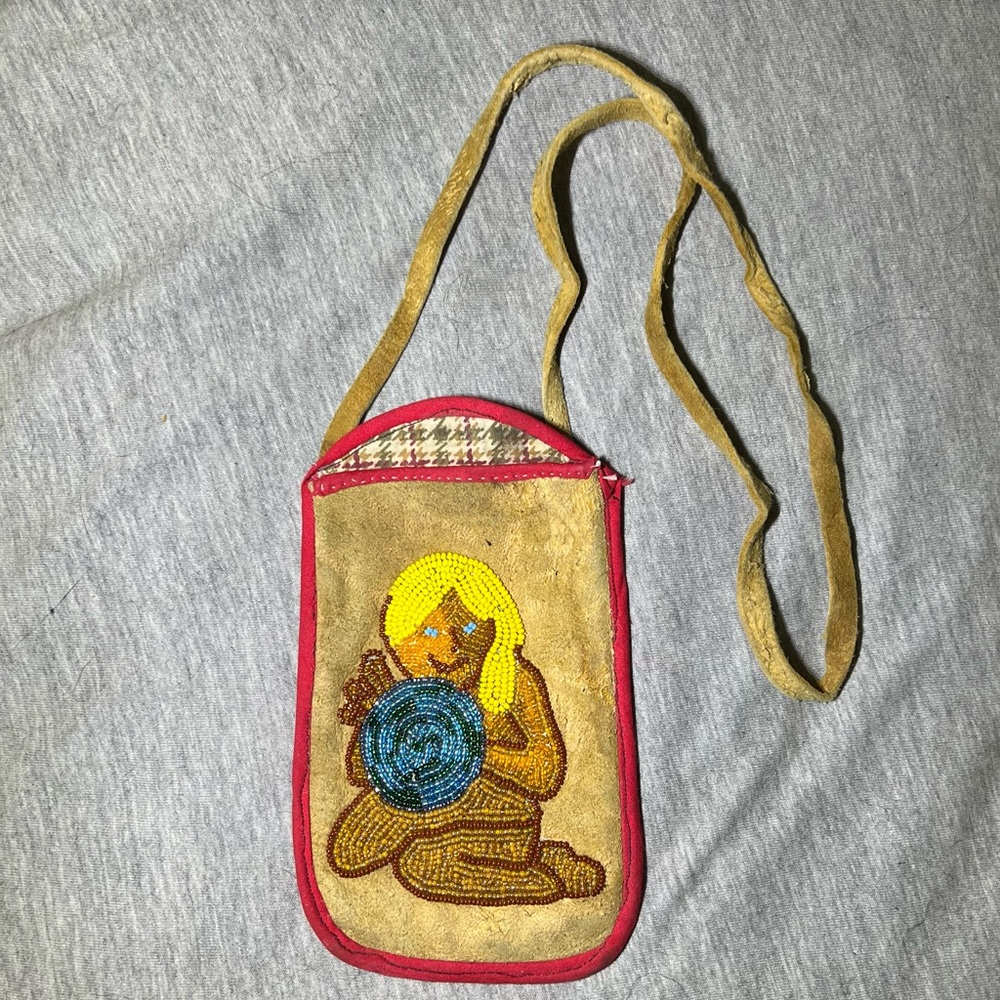 Beaded Women holding the world leather purse